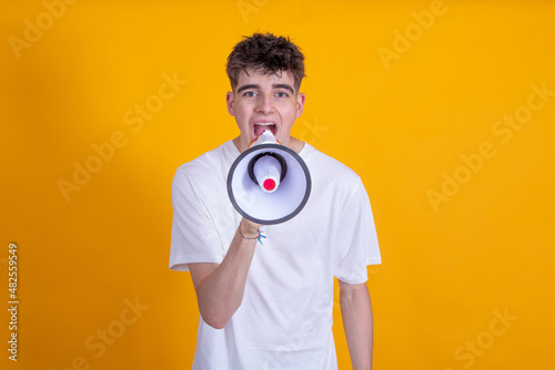 teenager boy with megaphone yelling isolated on background