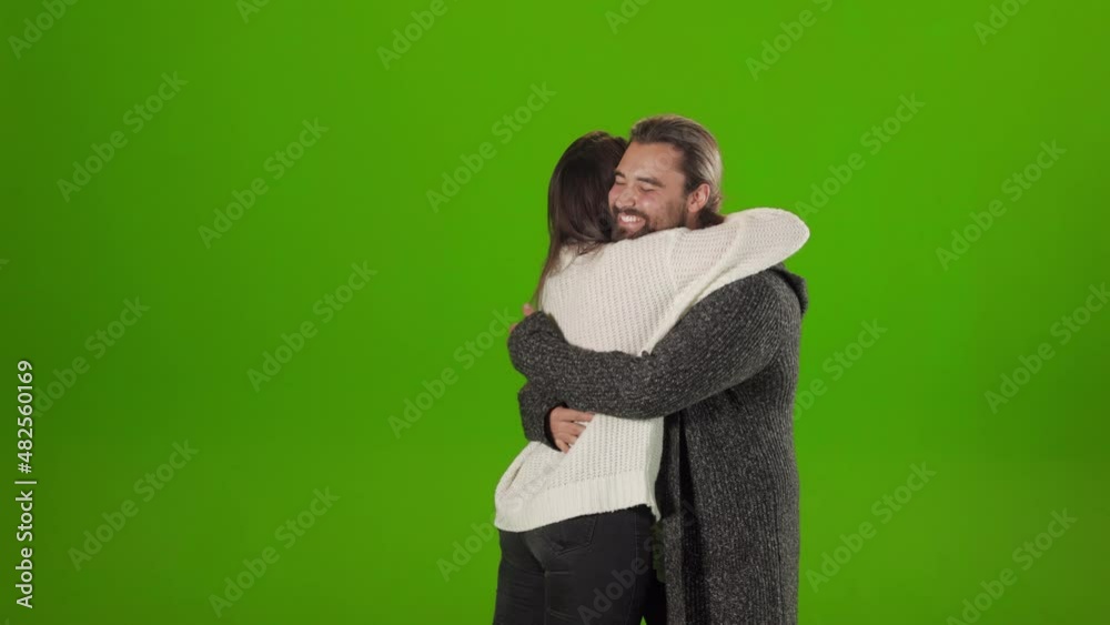 Beautiful woman and handsome man giving high five for greeting each other. Happy friends in casual clothes embracing during meeting over green background. Beautiful woman and handsome man giving high five for greeting each other. Happy friends in casual clothes embracing during meeting over green background.