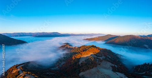 Fototapeta Naklejka Na Ścianę i Meble -  Thick fog among peaks of high autumn mountains at sunrise