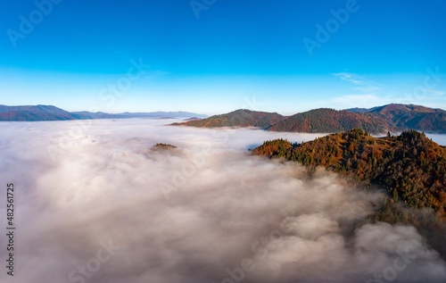 Fog among peaks of high autumn mountains with forests © YouraPechkin