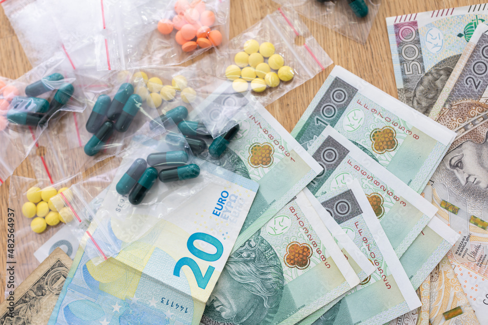 On the table lies currency in banknotes of various countries, and bagged drugs. On the table lies currency in banknotes of various countries, and bagged drugs.