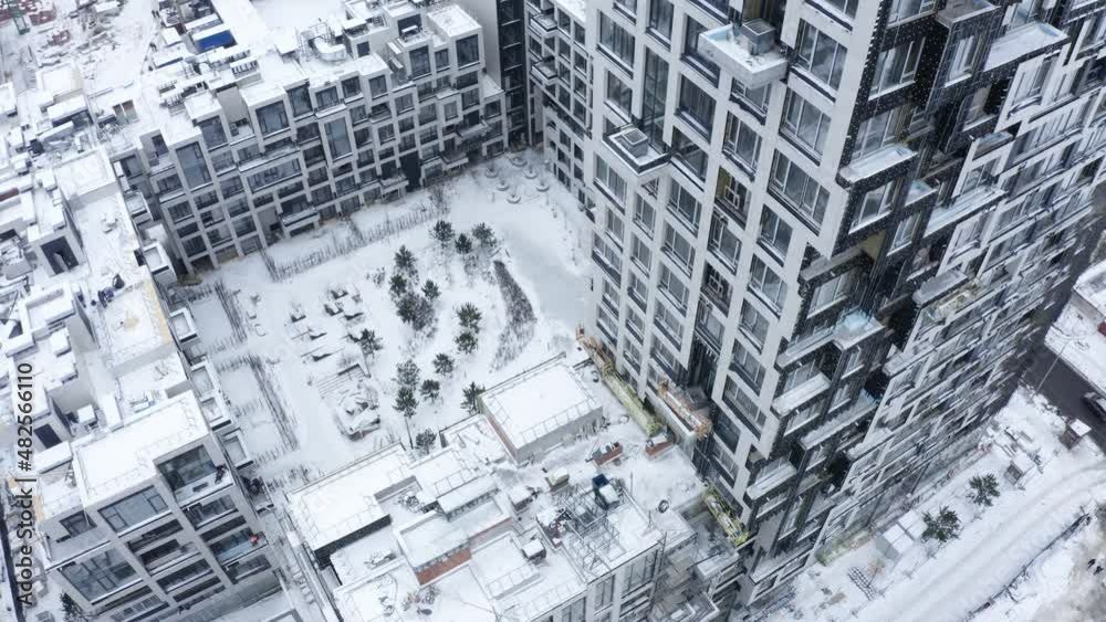 Aerial view of landscape top of the winter town residential houses with snow on covered houses and roads. Aerial snow covered homes and yards. Abandoned city covered in snow. Aerial view of landscape top of the winter town residential houses with snow on covered houses and roads. Aerial snow covered homes and yards. Abandoned city covered in snow.