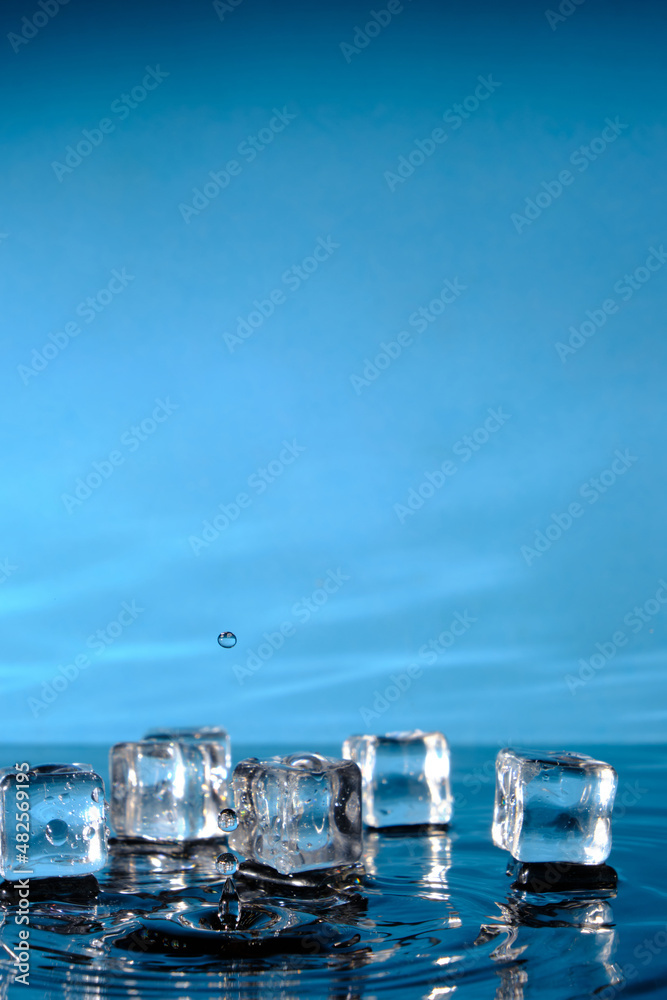 Ice cubes in bright blue water and a splash of raindrops. Ice cubes in bright blue water and a splash of raindrops.