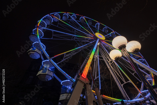 Ferris wheel beautifully illuminated at night in Leeds by the City Town Hall.