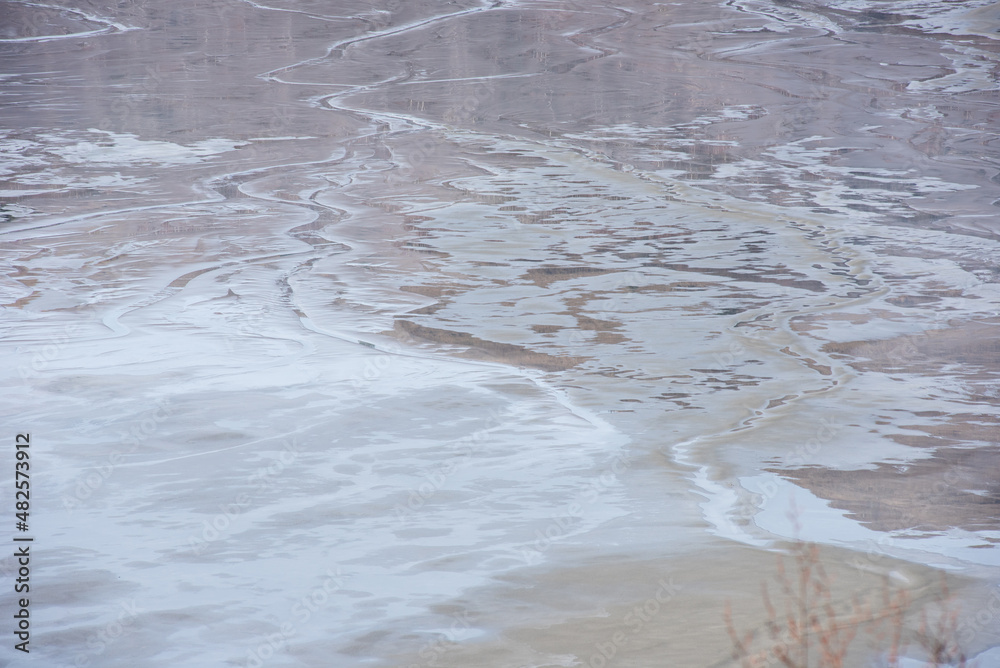 Muddy waters in a decantation pond. Toxic residuals from a copper mine decating in a settling basin