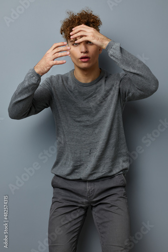 Attractive man in a gray sweatshirt fashion studio isolated background © Tatiana