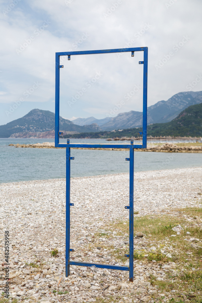Blue metal structure for an advertising poster on the seashore.