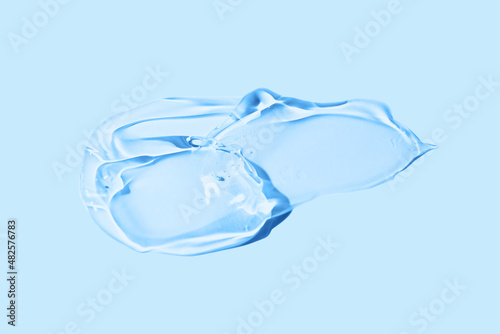 Liquid gel smear isolated on blue background. Beauty cosmetic smudge such as pure transparent aloe lotion, facial jelly serum, cleanser, shower gel or shampoo top view