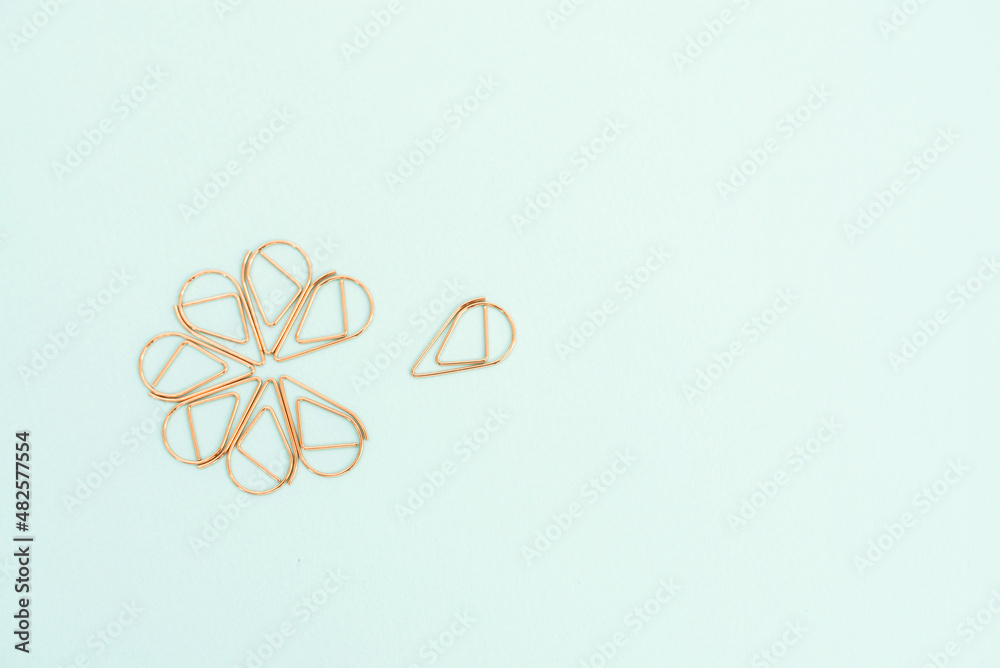 copper color office paperclips on light blue background copper color office paperclips on light blue background