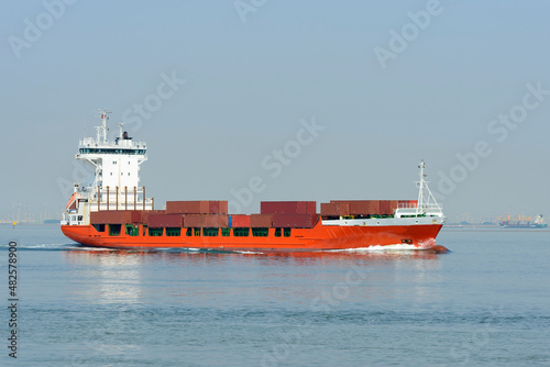 Feeder container cargo ship underway on a bright sunny day 