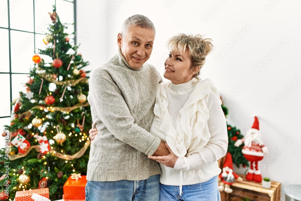 Middle age caucasian couple smiling happy and hugging celebrating christmas at home. Middle age caucasian couple smiling happy and hugging celebrating christmas at home.