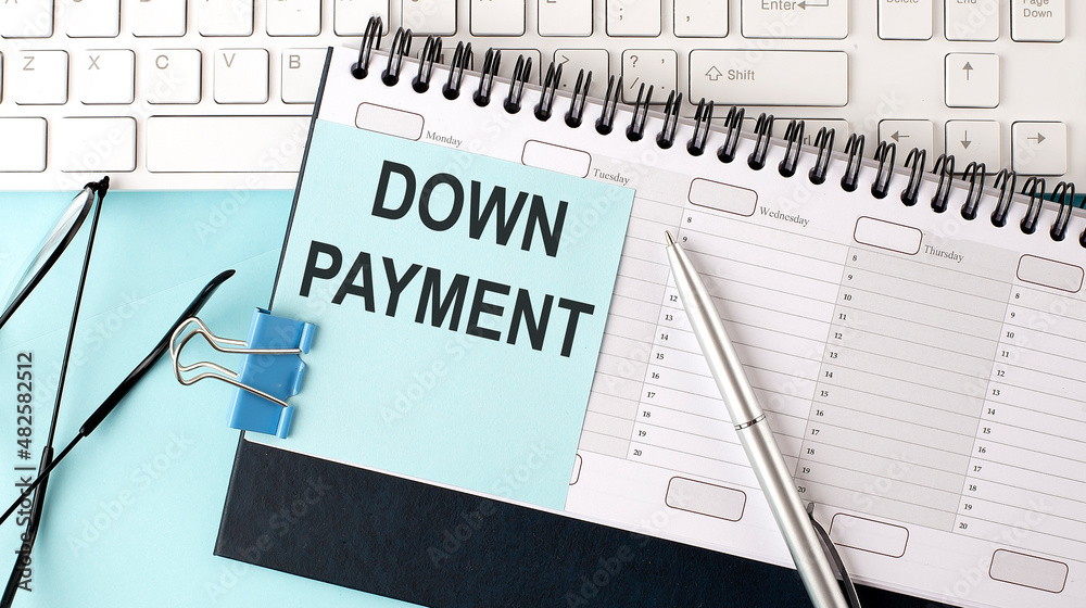 DOWN PAYMENT text on blue sticker on planning and keyboard,blue background DOWN PAYMENT text on blue sticker on planning and keyboard,blue background