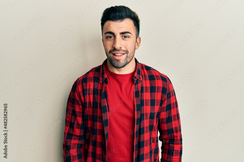 Young hispanic man wearing casual clothes with a happy and cool smile on face. lucky person. Young hispanic man wearing casual clothes with a happy and cool smile on face. lucky person.