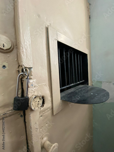 barred window in a white prison door