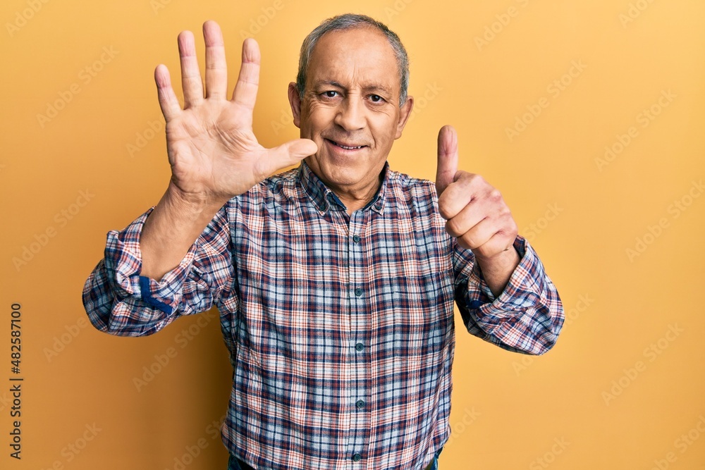 Handsome senior man with grey hair wearing casual shirt showing and pointing up with fingers number six while smiling confident and happy. Handsome senior man with grey hair wearing casual shirt showing and pointing up with fingers number six while smiling confident and happy.