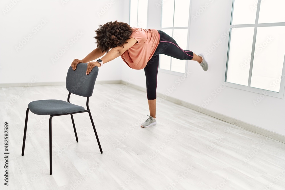 Young african american woman stretching at sport center Young african american woman stretching at sport center
