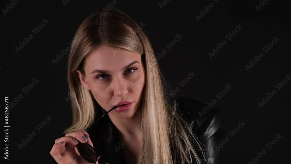 Blond woman biting her glasses Blond woman biting her glasses