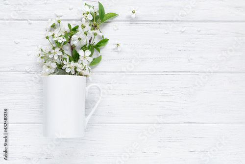 Spring mug mockup with blossom cherry, flat lay on wood background with copy space © studiomay