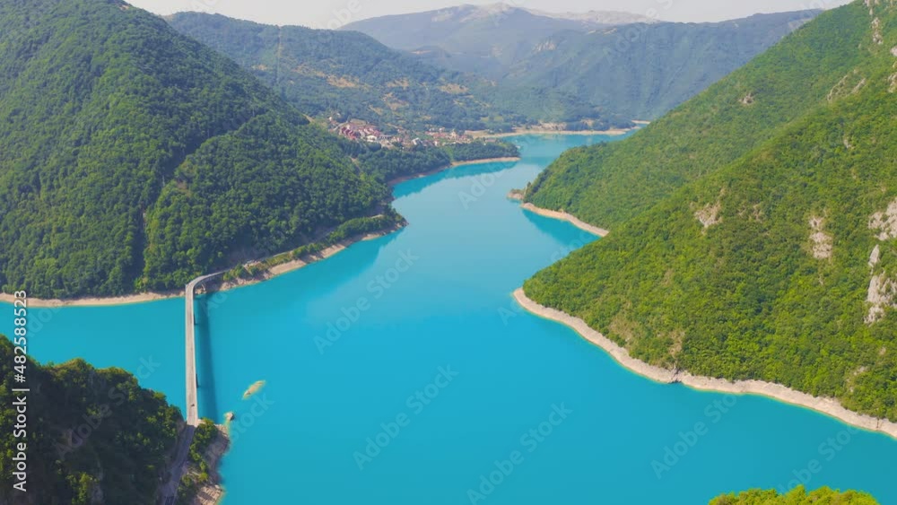 Aerial view on Piva lake with bridge, located between the mountains. The lake is an artificial reservoir of fresh water in Montenegro. Aerial view on Piva lake with bridge, located between the mountains. The lake is an artificial reservoir of fresh water in Montenegro.