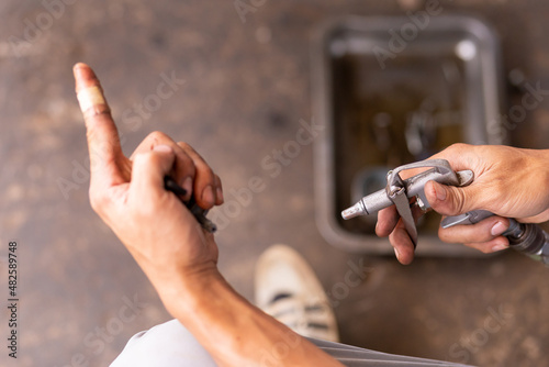 selective focus air blow gun in the hands of a motorcyclist Cleaning motorbike parts with air