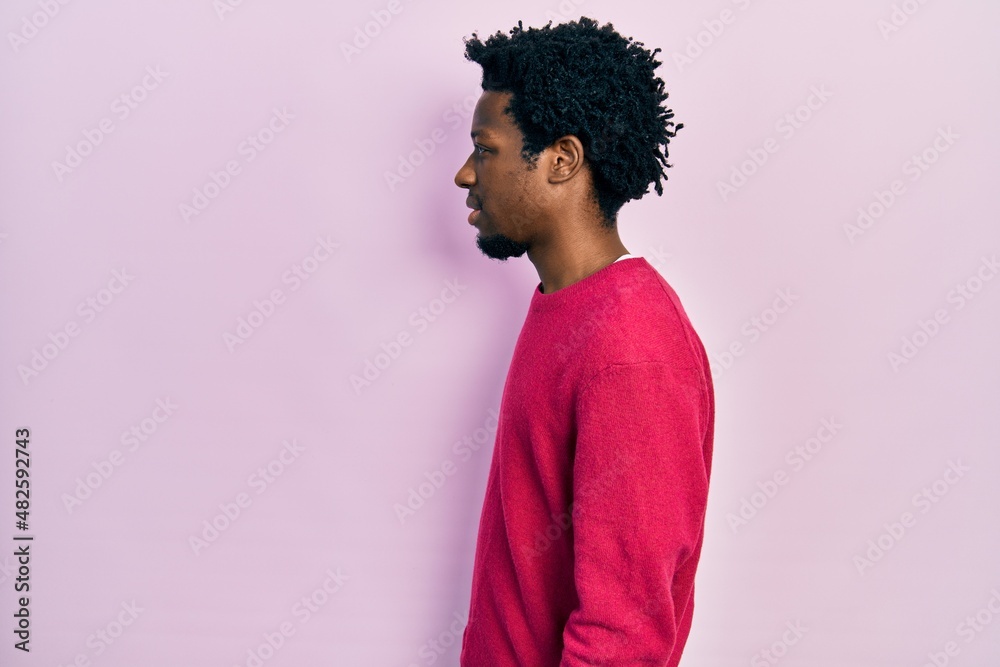 Young african american man wearing casual clothes looking to side, relax profile pose with natural face and confident smile. Young african american man wearing casual clothes looking to side, relax profile pose with natural face and confident smile.