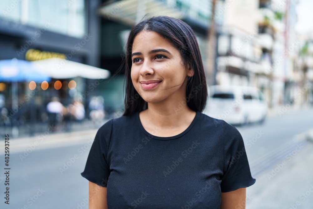 Young latin woman smiling confident standing at street
