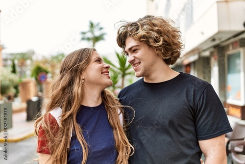 Young caucasian couple smiling happy and hugging at the city.