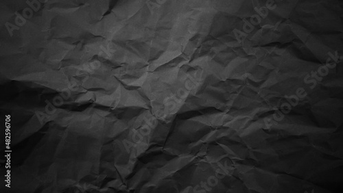 Textured crumpled black paper background. © prasong.