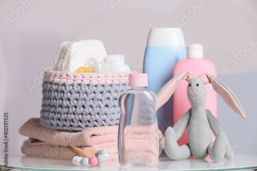 Vászonkép Baby cosmetic products, toys and accessories on white table against color backgr