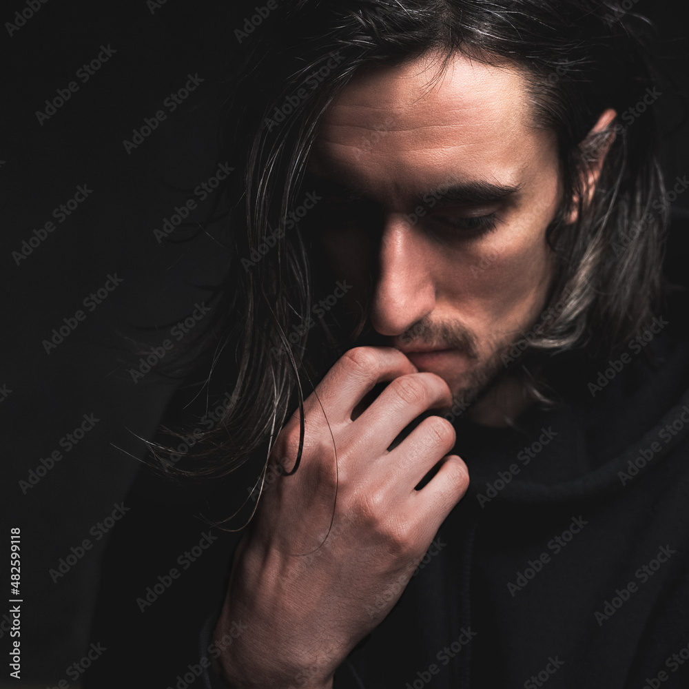 Young man with long hair thinking Young man with long hair thinking