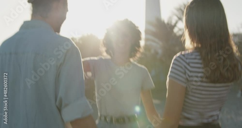 Friends walking and greeting on beach in sun during weekend meeting