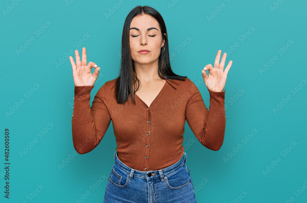 Young hispanic woman wearing casual clothes relax and smiling with eyes closed doing meditation gesture with fingers. yoga concept.
