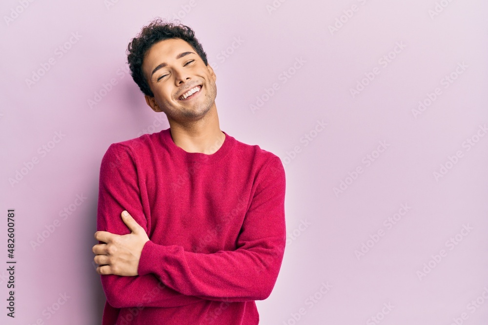 Handsome hispanic man wearing casual clothes over pink background happy face smiling with crossed arms looking at the camera. positive person. Handsome hispanic man wearing casual clothes over pink background happy face smiling with crossed arms looking at the camera. positive person.