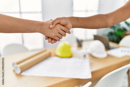 Young african american woman doing handshake at architecture studio