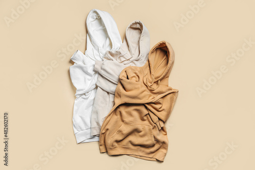 Three hoodies in white and beige colors. Fashion outfit, casual youth style, sports. Stylish autumn or spring  clothes. photo