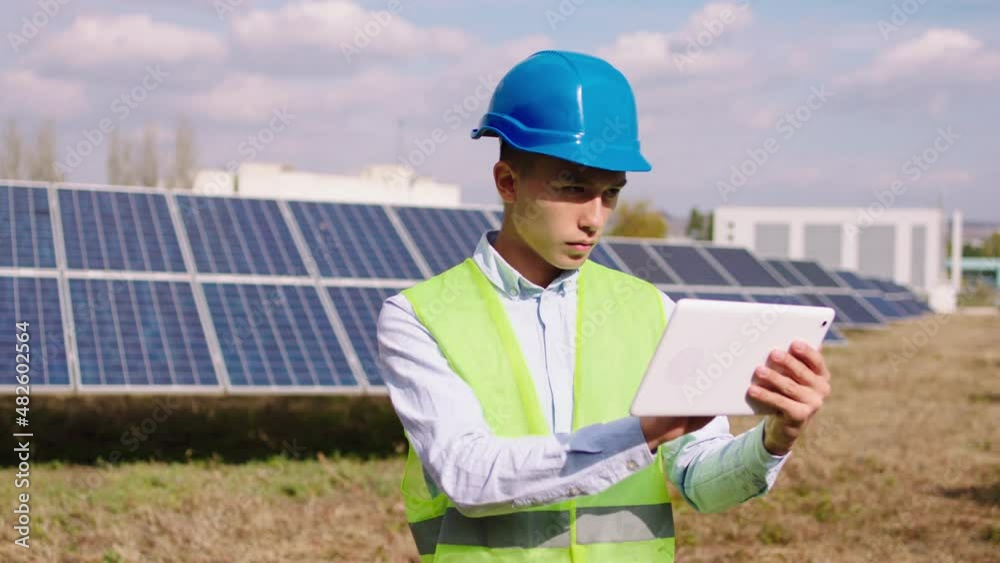 Young ecological engineer take some efficient information about solar panels using the digital tablet he controlling photovoltaic battery solar farm. 4k Young ecological engineer take some efficient information about solar panels using the digital tablet he controlling photovoltaic battery solar farm. 4k