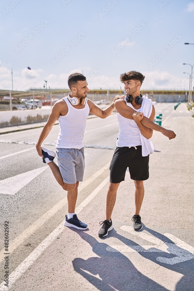 Two hispanic men couple smiling confident stretching at street Two hispanic men couple smiling confident stretching at street