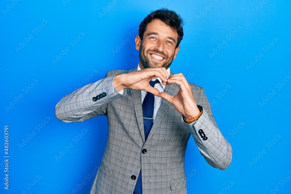 Handsome man with beard wearing business suit and tie smiling in love ...