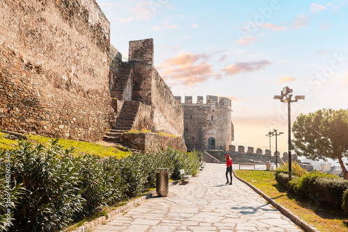 Tourist girl visitor walks to the entrance of the Trigonion or Chain Tower in Upper Town of Ano poli in Thessaloniki, Greece
