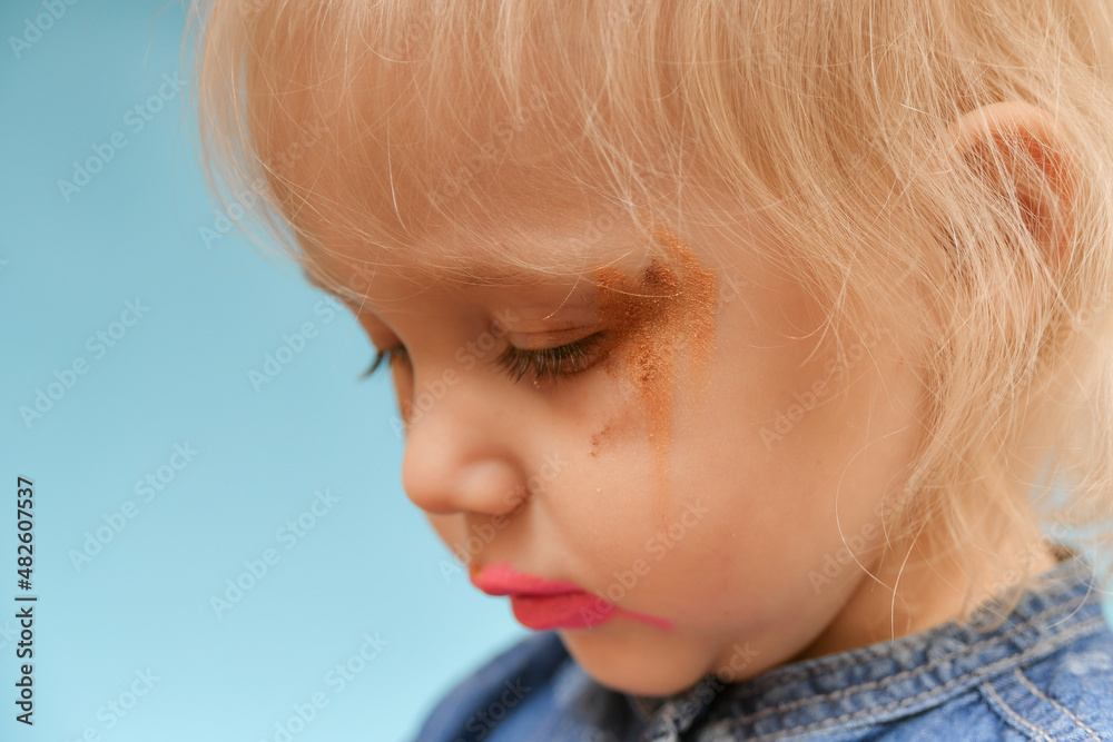 A portrait of a child who put on parental makeup on his own. Small children and high fashion. A portrait of a child who put on parental makeup on his own. Small children and high fashion.