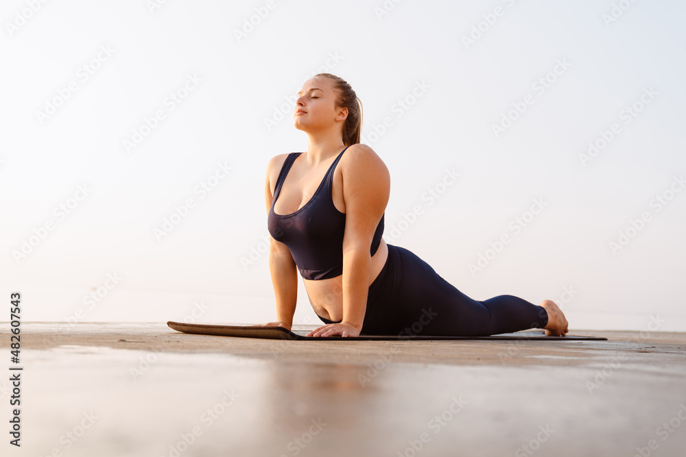 Young ginger woman doing exercise during yoga practice
