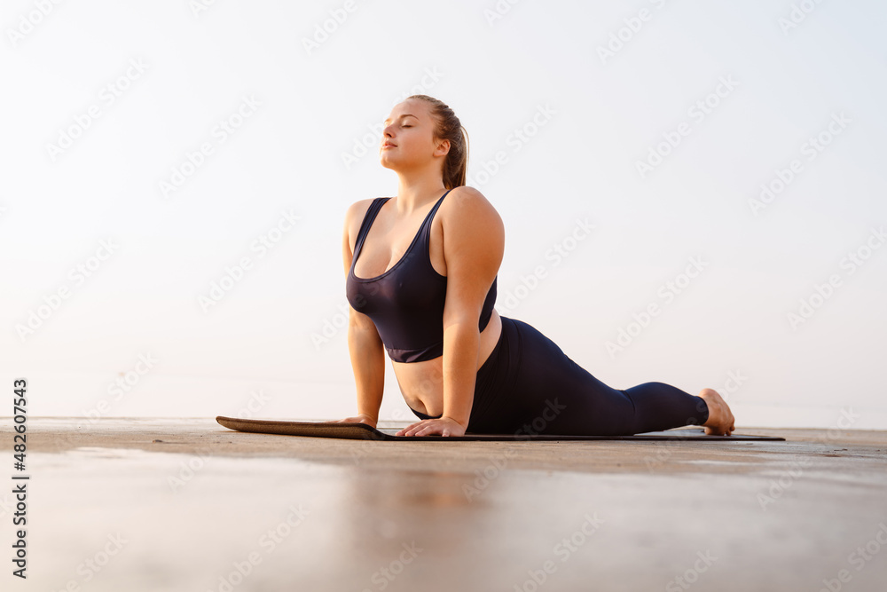 Young ginger woman doing exercise during yoga practice Young ginger woman doing exercise during yoga practice