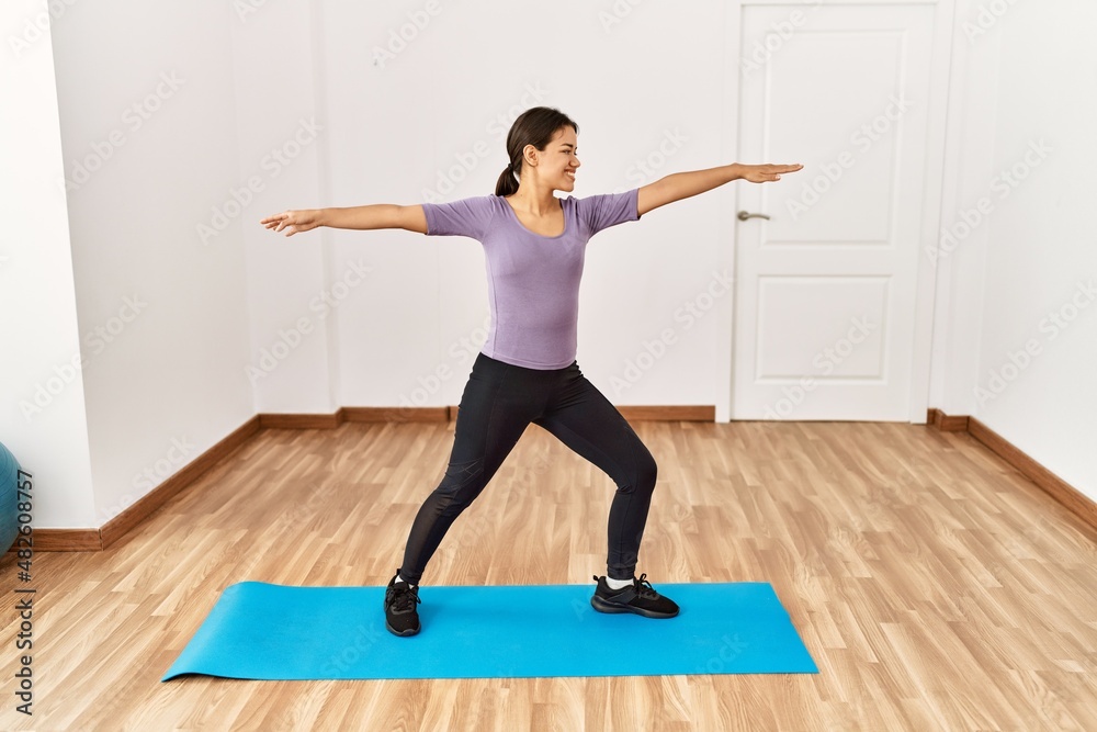 Young latin woman smiling confident training yoga at sport center