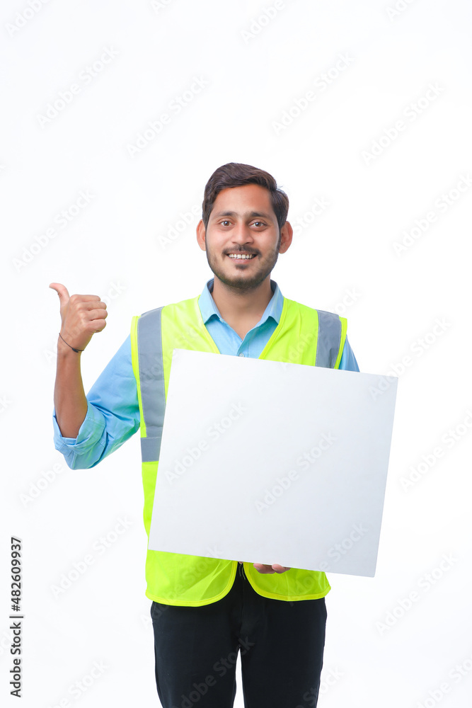 Young indian Construction Worker Showing Empty Poster Board on White Background. Young indian Construction Worker Showing Empty Poster Board on White Background.