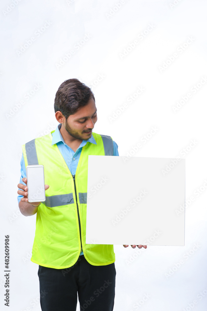 Young engineer showing smartphone screen and empty board on white background. Young engineer showing smartphone screen and empty board on white background.