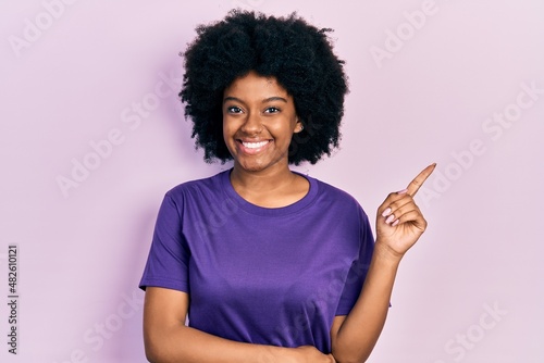 Young african american woman wearing casual clothes smiling happy pointing with hand and finger to the side