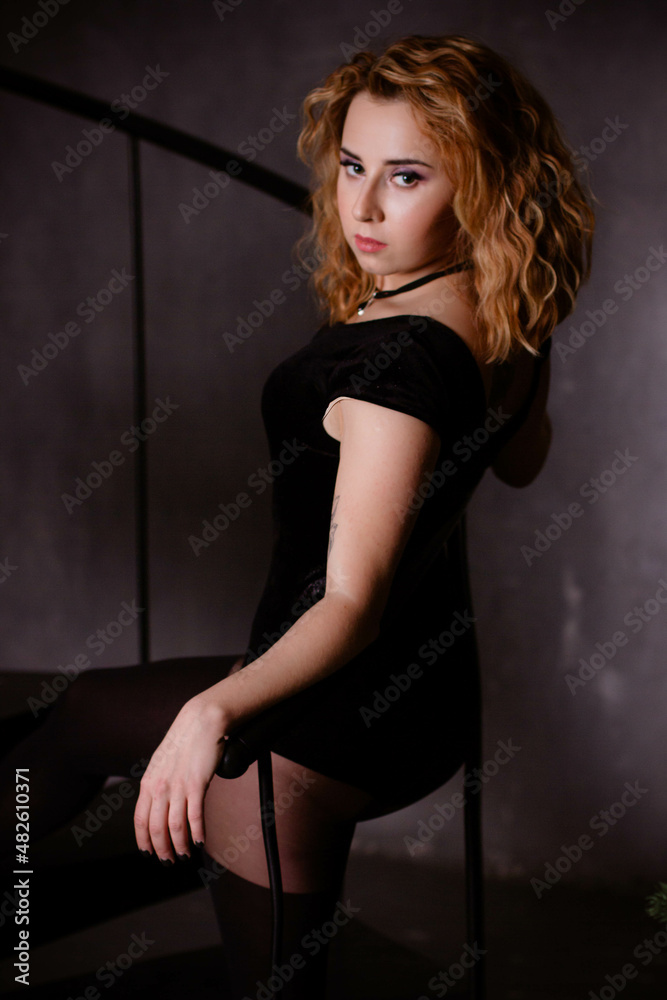 Young woman with red hair posing in studio