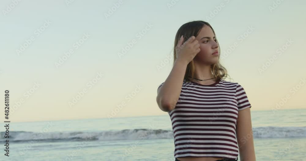 Portrait of young woman standing on beach in front of sea with smile Portrait of young woman standing on beach in front of sea with smile