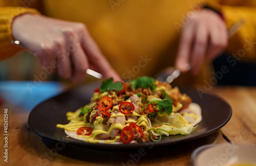 Woman eats traditional taco with meat in restaurant.