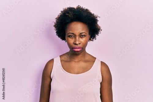 Young african american woman wearing casual sleeveless t shirt skeptic and nervous, frowning upset because of problem. negative person.